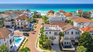A coastal residential area with houses, a swimming pool, and a view of the ocean. - Destiny In Emerald Green 3 Bedroom Home (Destin)