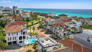A coastal residential area with a large building featuring a swimming pool and multiple balconies. - Destiny In Emerald Green 3 Bedroom Home (Destin)