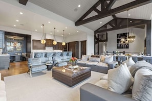 A spacious living area with a modern kitchen, dining area, and a large sofa set. - Abode on Ruby Run, ski-in/ski-out, hot tub, sauna, fire pit (Park City)