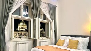 Ein Hotelzimmer mit Bett, Blick auf ein historisches Gebäude und einer Heizung.