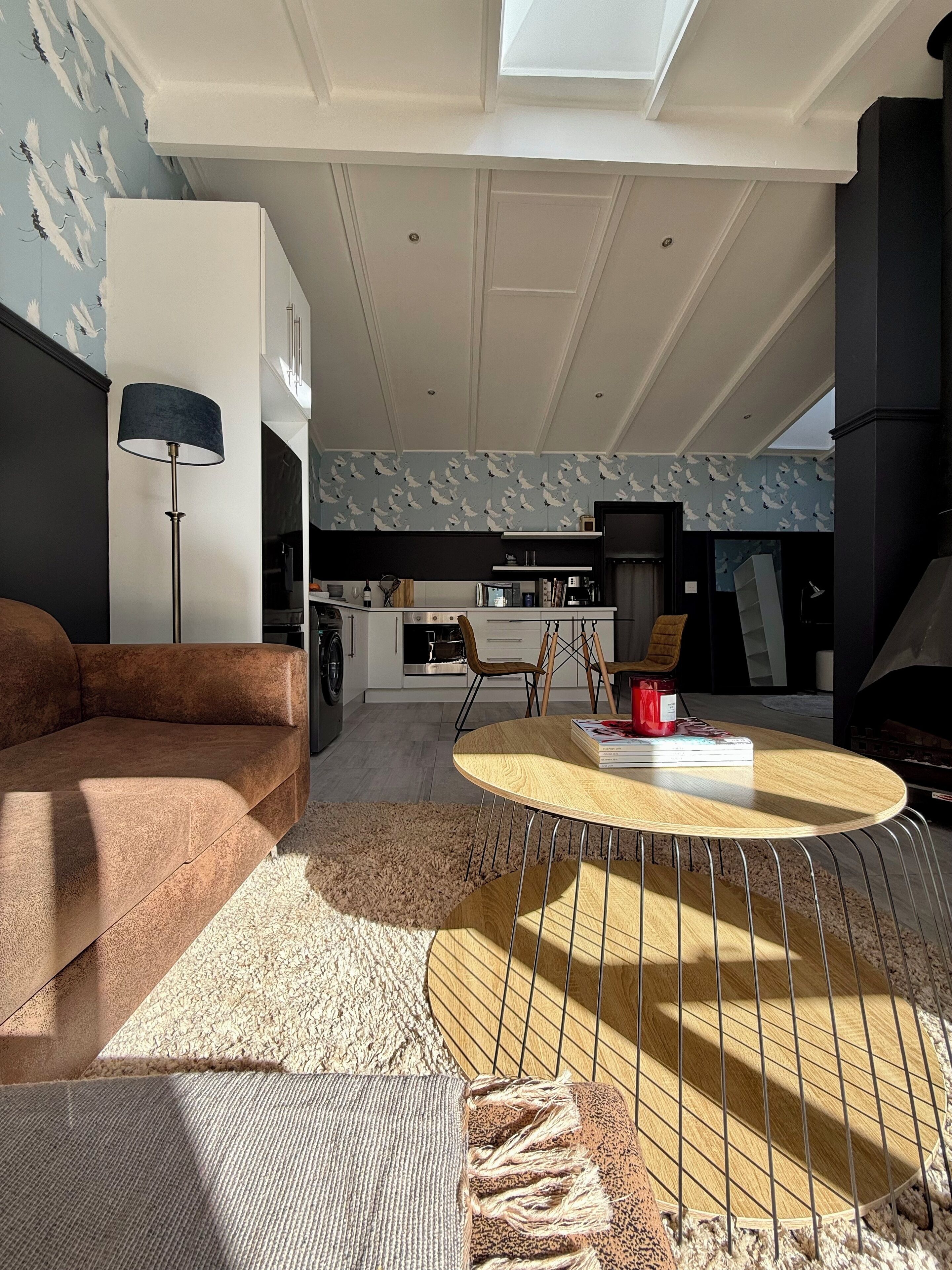 A modern living room with a sofa, a coffee table, and a fireplace.