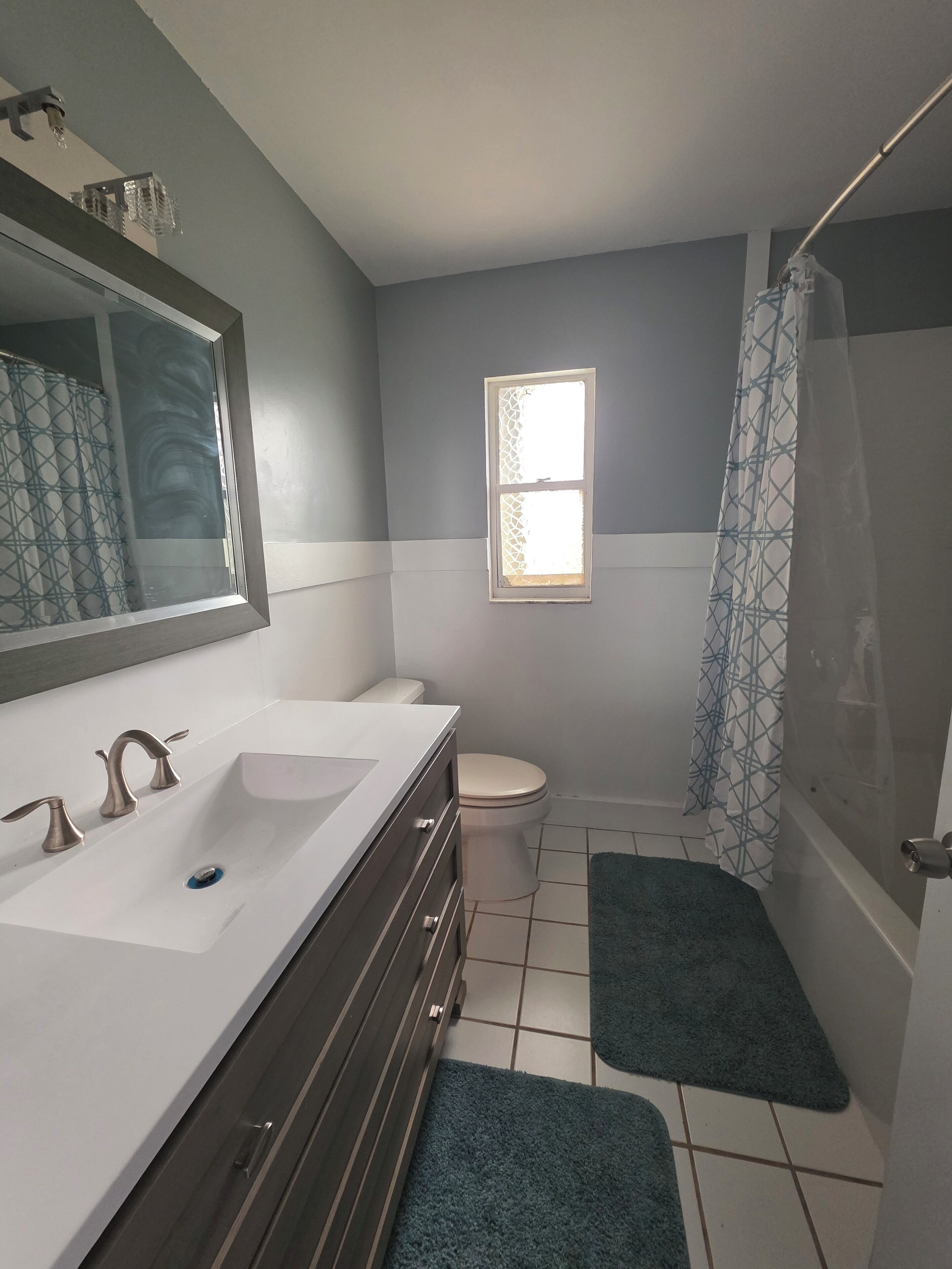 Een badkamer met een dubbele wastafel, toilet en douche.