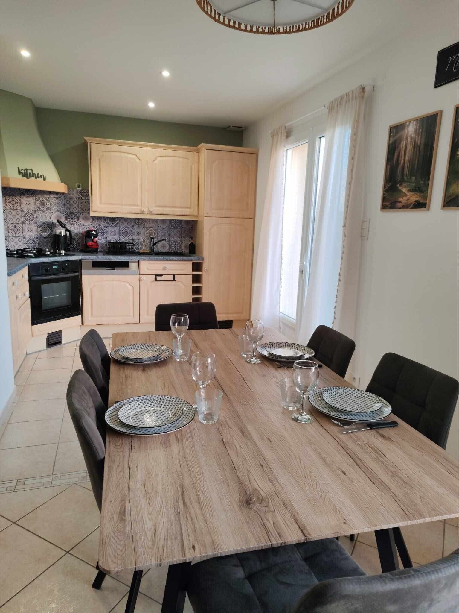 Comedor con una mesa de madera dispuesta para seis personas, rodeado de sillas.