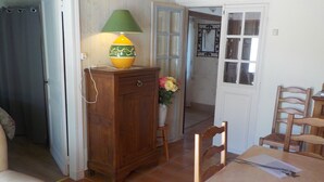 A dining area with a wooden table, chairs, a cabinet with a lamp, and a vase with flowers. - Holiday Home 'Gite618' (Helfaut)