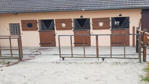 A building with multiple wooden doors and a metal gate in front. - Holiday Home 'Gite618' (Helfaut)