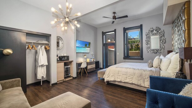 A bedroom with a bed, a desk, a chair, a wardrobe, and a ceiling fan. - Good Hotels Downtown Denver (Denver)