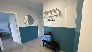 A hallway with a bench, a mirror, a coat rack, and a wall-mounted heater. - Renovated EFH, Schwerin lake district. Nature and culture within easy reach (Leezen)