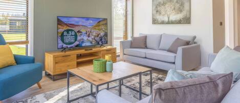 A modern living room with a television, sofa, and coffee table.