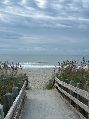 A wooden boardwalk leading to a sandy beach with overcast skies. - White Shores-Quiet 2BR/2BA Condo + Pool's near beach in North Myrtle Beach SC (North Myrtle Beach)