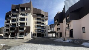 Een modern appartementencomplex met meerdere balkons en een overdekte entree.
