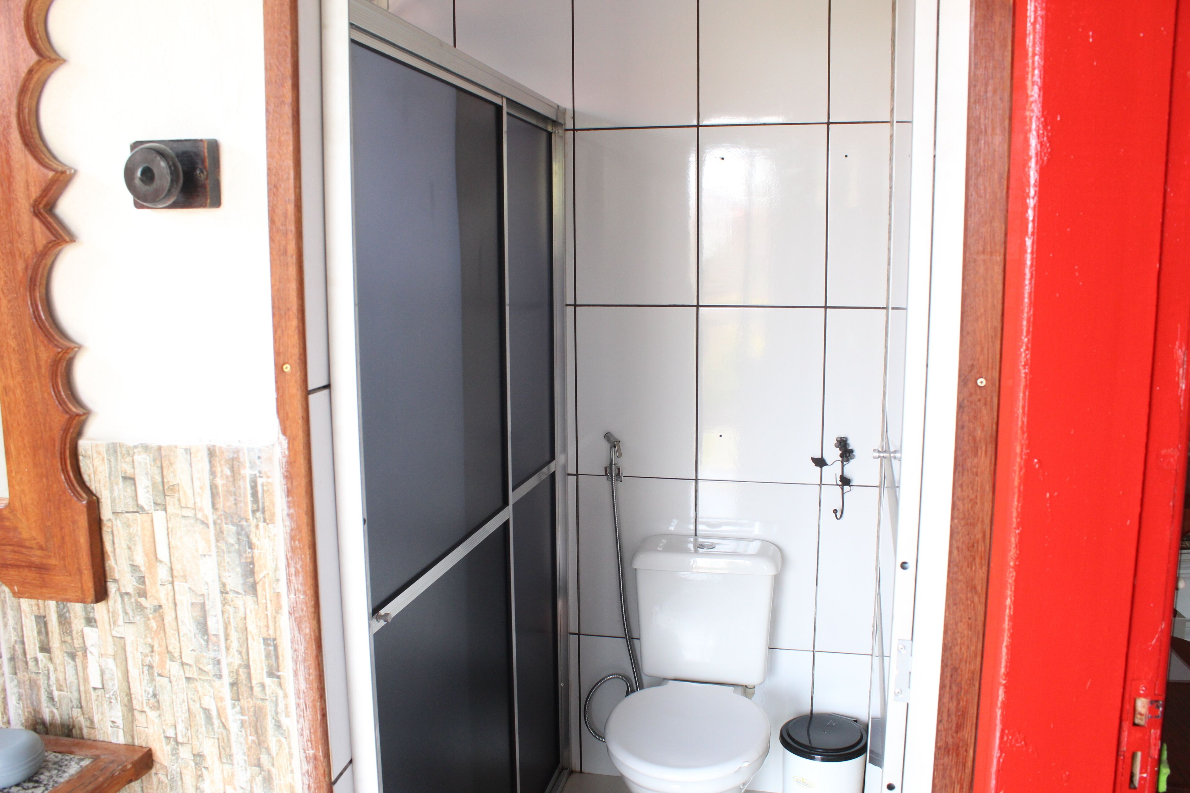 A small bathroom with a toilet, a shower, and a sink.