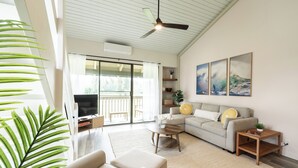 A modern living room with a sofa, coffee table, and a ceiling fan. - Charming Renovated Condo w/Loft & Golf Views near Ritz-Carlton Turtle Bay (Kahuku)