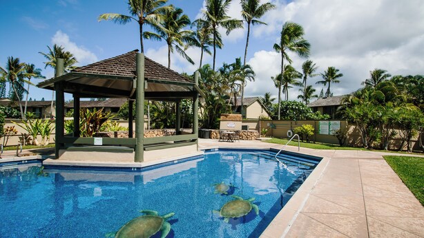A swimming pool with three sea turtles, surrounded by palm trees and a gazebo. - Charming Renovated Condo w/Loft & Golf Views near Ritz-Carlton Turtle Bay (Kahuku)