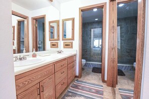 A bathroom with wooden cabinets, two sinks, and a shower area. - Plaza 536 | Shuttle to Crested Butte Lifts | Hot Tubs+Sauna | 2BR Sleeps 6 (Crested Butte)