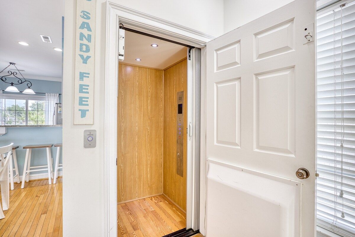 Ein Flur mit einer weißen Tür, einem hölzernen Aufzug und einer Wand mit einem Schild.