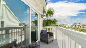 A balcony with wicker furniture and a view of other buildings. - Beach Buddies 2 w/pool (North Myrtle Beach)