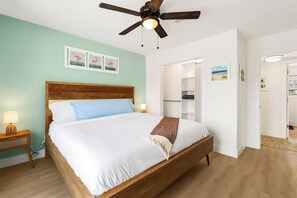 Ein Schlafzimmer mit einem hölzernen Bett, einem Deckenventilator und einer Wand mit gerahmten Bildern.