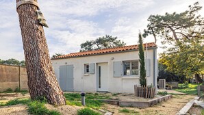 Una casa con techo de tejas, una puerta y una ventana con contraventanas.