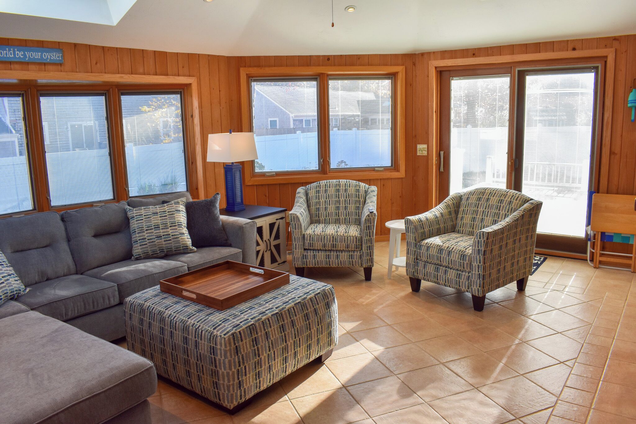 A living room with a sofa, two armchairs, a coffee table, and a lamp.
