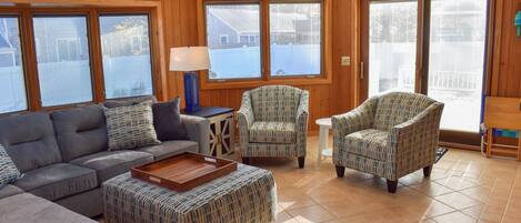 A living room with a sofa, two armchairs, a coffee table, and a lamp.