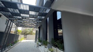 A covered walkway with a modern design, featuring a metal roof and concrete steps.