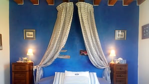 A bedroom with a bed, two nightstands, a lamp, a blue wall, and a framed picture. - Blue Azur Guest Room with Shared Terrace & Garden, Wi-Fi (Honfleur)