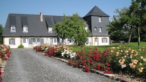 A large house with a gravel driveway, surrounded by a well-maintained garden with various flowers. - Blue Azur Guest Room with Shared Terrace & Garden, Wi-Fi (Honfleur)
