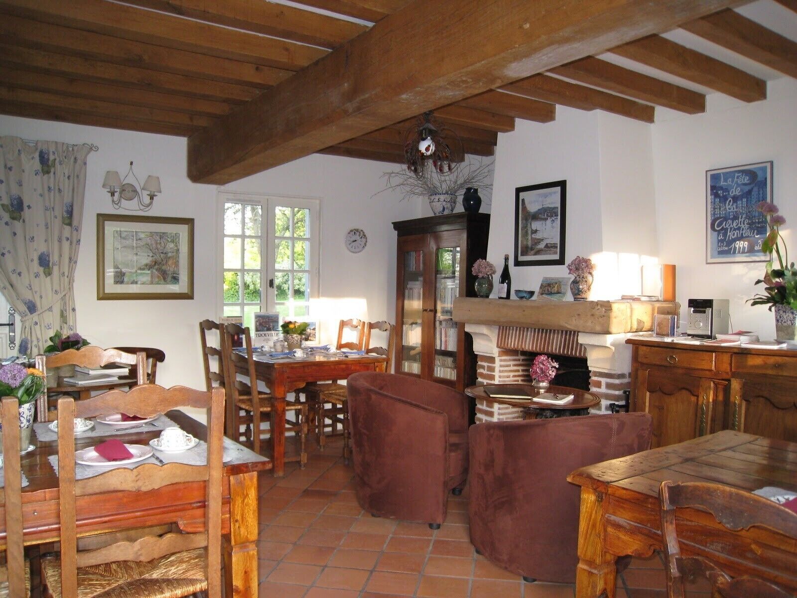 A rustic dining area with wooden furniture, a fireplace, and a bookshelf.