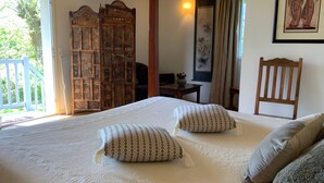 Ein Schlafzimmer mit einem großen Bett, zwei Kissen, einem Holzschrank, einem Schreibtisch und einem Stuhl.