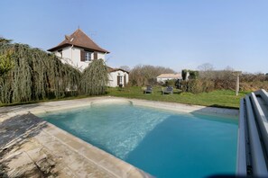 Une piscine avec une maison en arrière-plan.