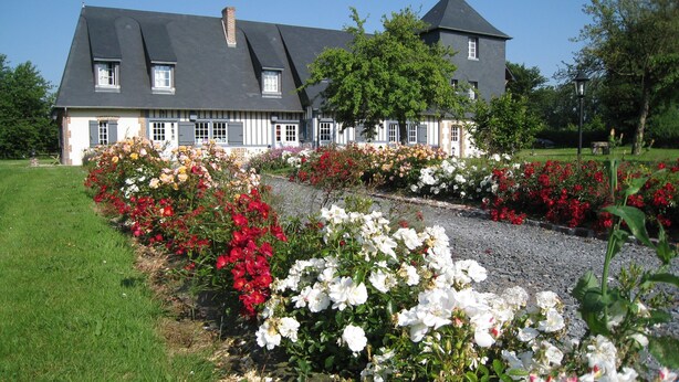 A large house with a grey roof and white trim, surrounded by a gravel path and colorful flower beds. - “Romantic Suite” Guest Room with Shared Terrace & Garden, Wi-Fi (Honfleur)