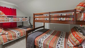 Une chambre avec un lit superposé, comportant deux lits, chacun avec une literie à motifs.
