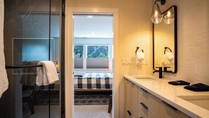 A modern bathroom with a large mirror, dual light fixtures, and a visible window. - Mountain View Villa - Lux 3BD W/roof Terrace - Downtown Hailey (Hailey)