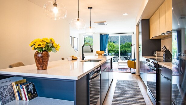 A modern kitchen with a central island, a dining area with a table and chairs, and a view of greenery outside. - Mountain View Villa - Lux 3BD W/roof Terrace - Downtown Hailey (Hailey)