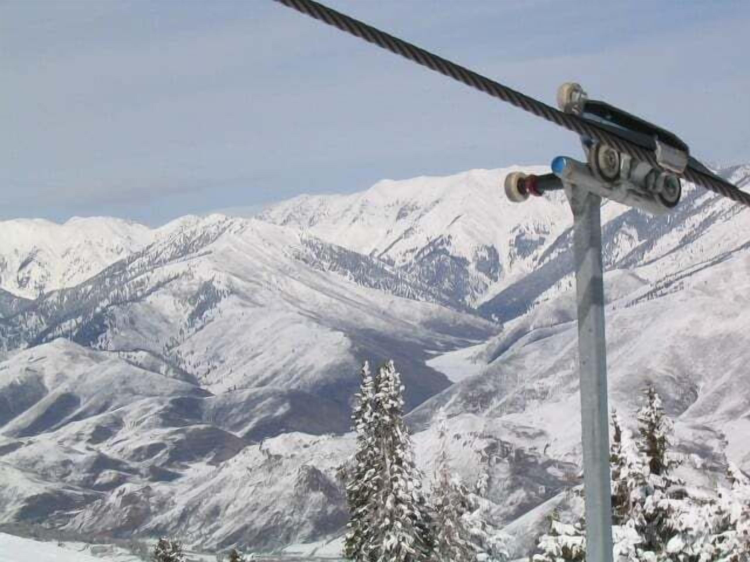 Um teleférico com paisagem de montanha nevada ao fundo.