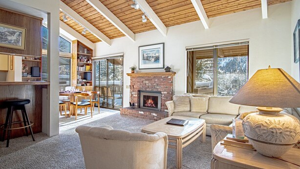 A cozy living room with a fireplace, a sofa, a coffee table, and a bookshelf. - Sv120 - Walk to Lifts & Town - Hot Tub & Pool (Ketchum)