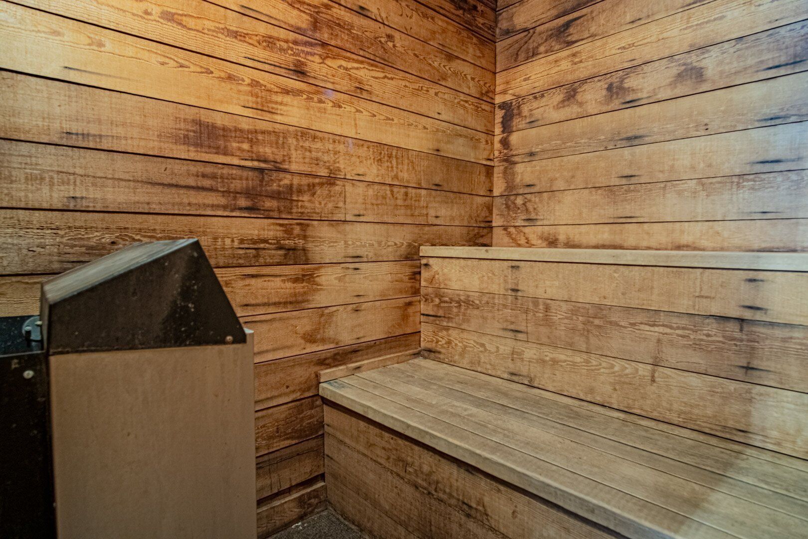 Un sauna avec des murs et des bancs en bois.