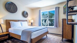 A hotel room with a bed, bedside tables, a window with curtains, and a view of the outside. - Della View 2BR Condo - In the Heart of Historic Downtown Hailey! (Hailey)