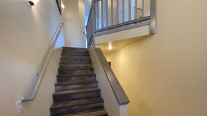 A staircase with dark wooden steps and a metal railing. - Della View 2BR Condo - In the Heart of Historic Downtown Hailey! (Hailey)