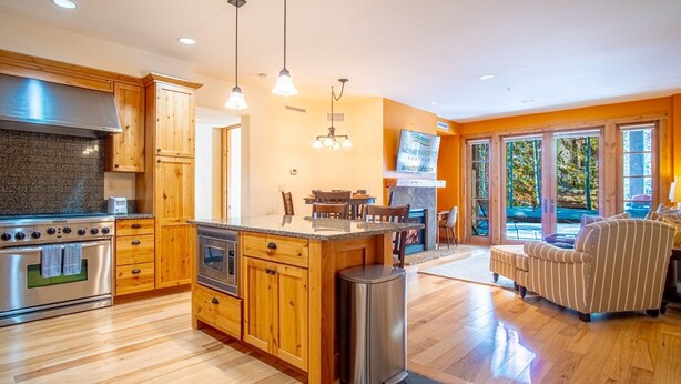 A modern kitchen with wooden cabinets, stainless steel appliances, and pendant lighting. - Elkhorn Springs Sanctuary - Pool/hot Tub/underground Parking (Sun Valley)