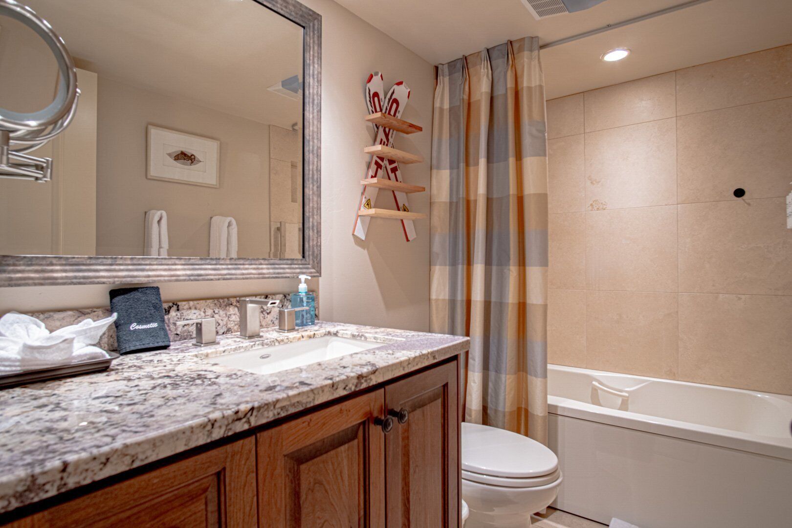 A bathroom with a marble sink, a toilet, and a bathtub.
