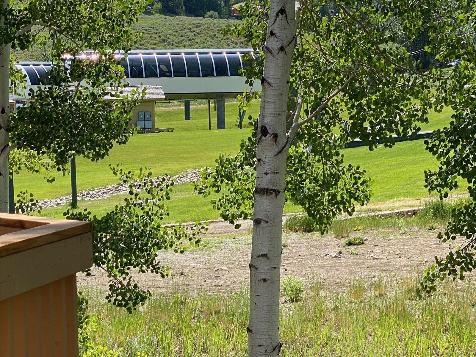 A view of a building with a green roof and a wooden deck in the foreground.