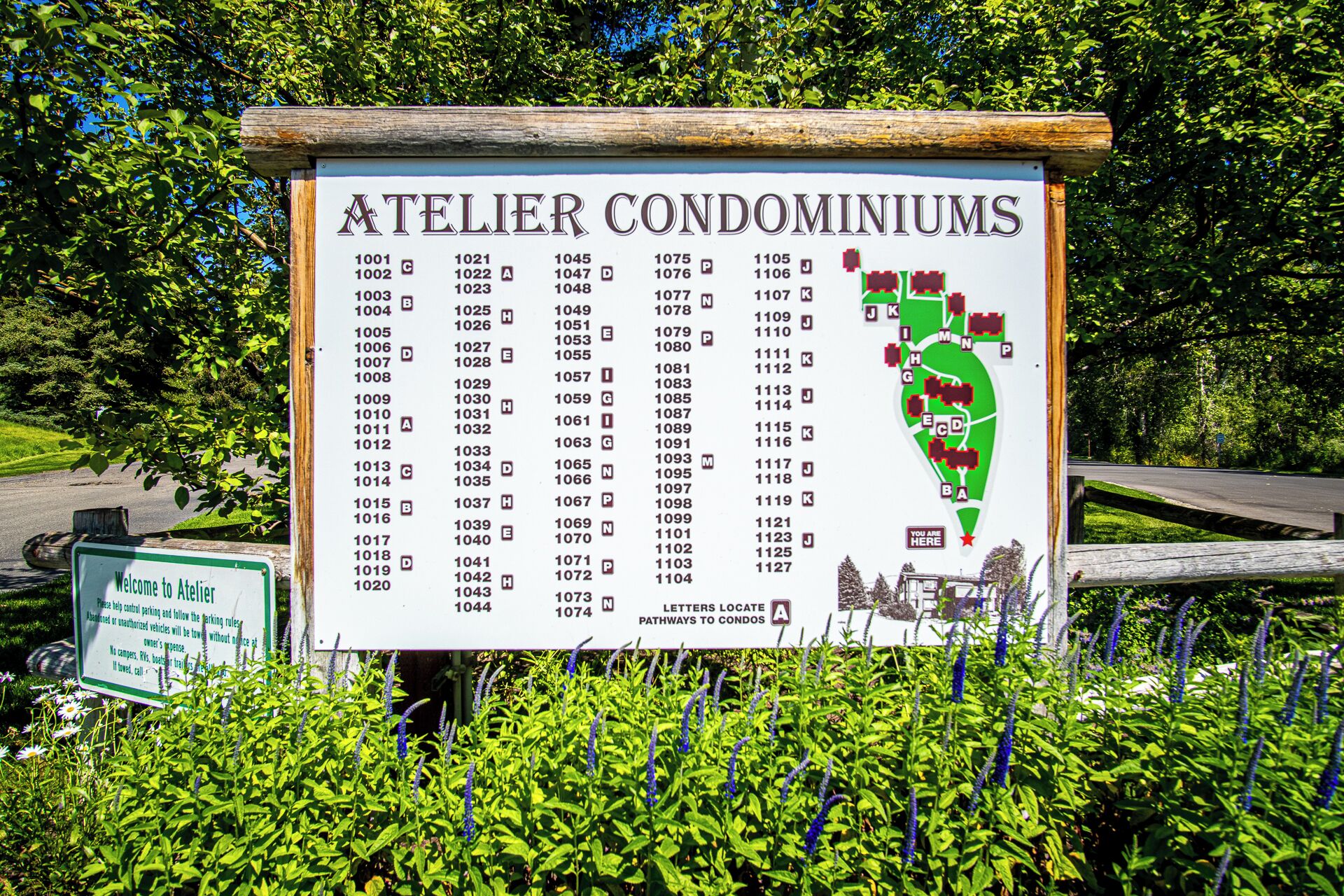 A sign for Atelier Condominiums listing condo numbers and letters.