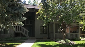 A building with a covered porch, a brick pathway, and a well-maintained lawn. - Sv155 - Walk to Lifts & Town - Hot Tub & Pool (Ketchum)