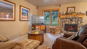 A cozy living room with a fireplace, comfortable seating, and framed artwork on the walls. - Sv155 - Walk to Lifts & Town - Hot Tub & Pool (Ketchum)