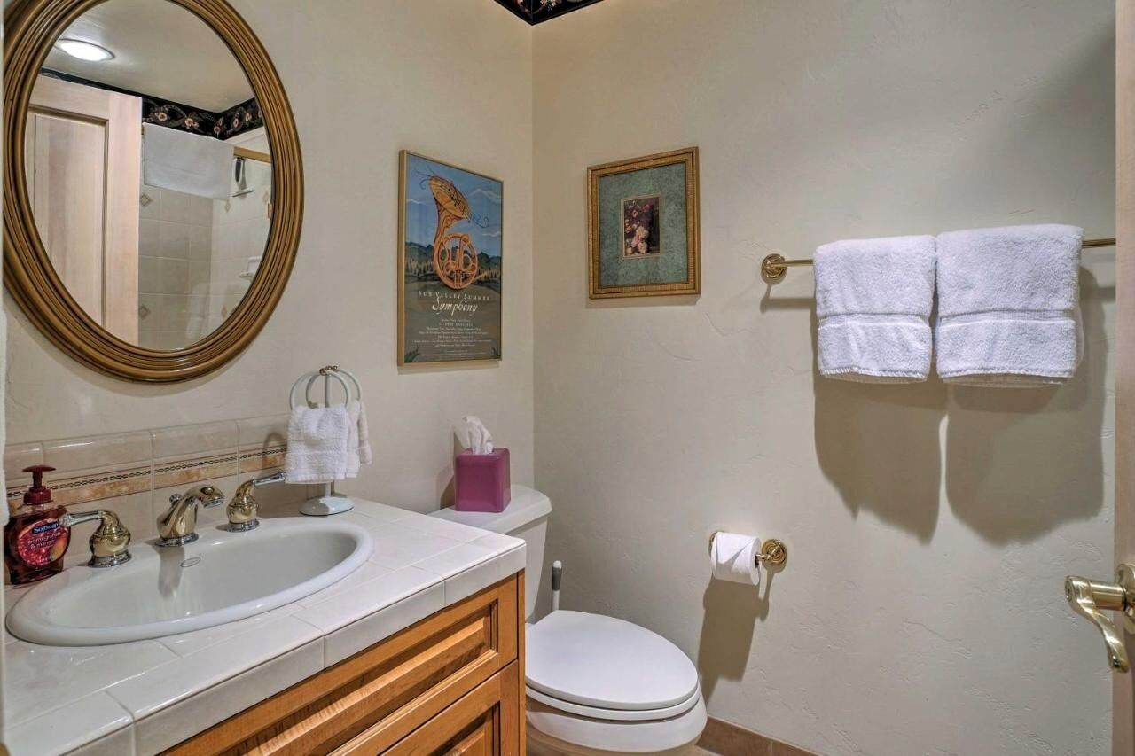 A bathroom with a sink, toilet, and a towel rack with two towels.
