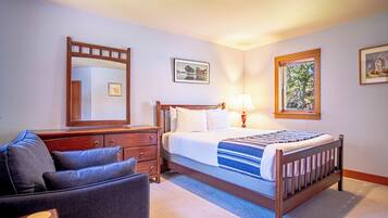 Une chambre à coucher avec un lit, une commode, une chaise, un miroir et une fenêtre.