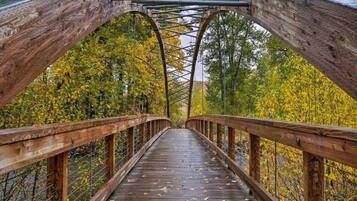 Eine Holzfußgängerbrücke mit Metallgeländern und einer Metallunterkonstruktion.