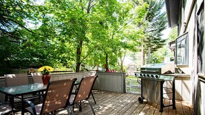 An outdoor patio with a table and chairs, a grill, and a wooden deck. - 3BD Downtown Ketchum Condo - Near Town & Ski Lifts (Ketchum)