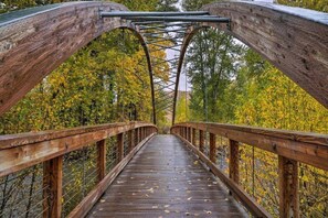 A wooden pedestrian bridge with metal railings and a metal support structure. - Elkhorn Bluff Condo + Complex & Resort Amenities (Sun Valley)